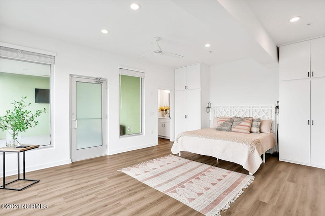 bedroom with ensuite bath, light hardwood / wood-style flooring, and ceiling fan