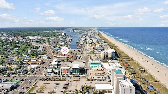 birds eye view of property with a water view and a beach view