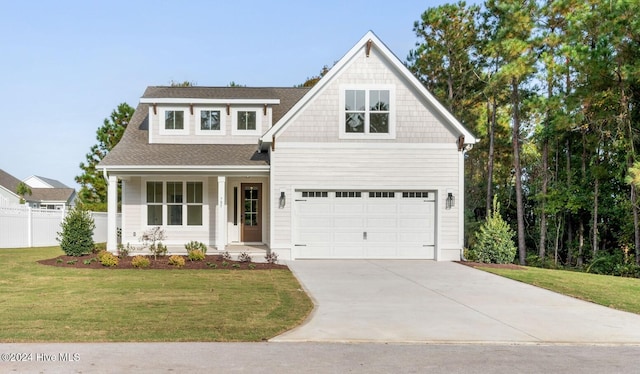 view of front of property featuring a front yard, fence, covered porch, a shingled roof, and concrete driveway