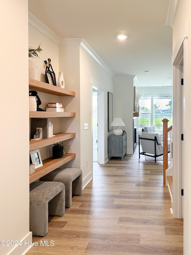 hall with crown molding and light hardwood / wood-style flooring