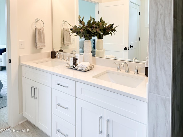 ensuite bathroom with ensuite bath, double vanity, and a sink