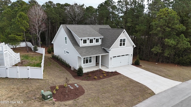 view of front facade with driveway, a gate, fence, a shingled roof, and a garage