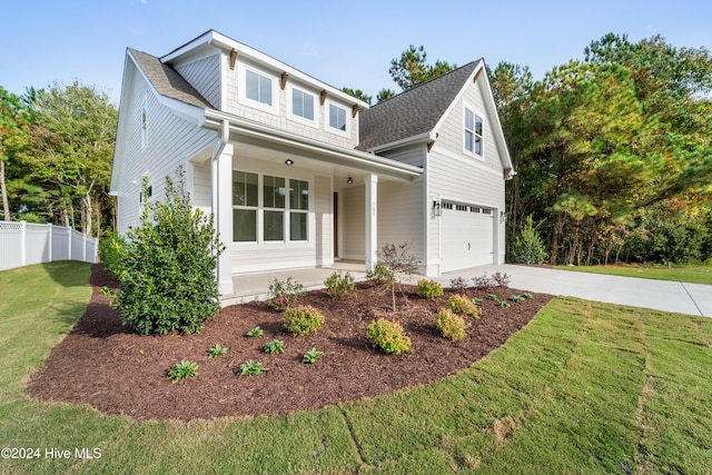 traditional home featuring fence, a porch, concrete driveway, a front yard, and an attached garage