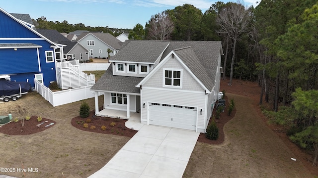 traditional home with fence, concrete driveway, and a shingled roof