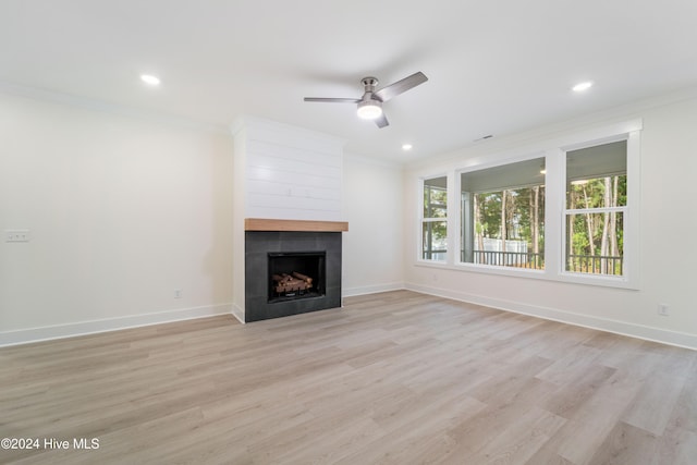 unfurnished living room featuring light hardwood / wood-style flooring, a fireplace, ornamental molding, and ceiling fan