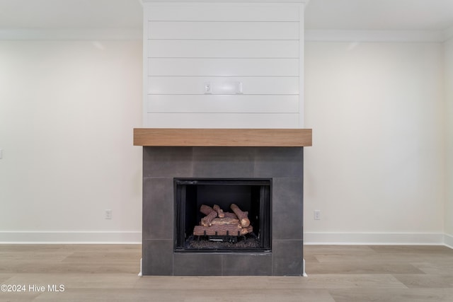 interior details with a fireplace, baseboards, and wood finished floors