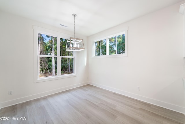 unfurnished dining area featuring light wood-type flooring