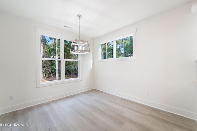 spare room with light wood-style flooring, visible vents, and baseboards