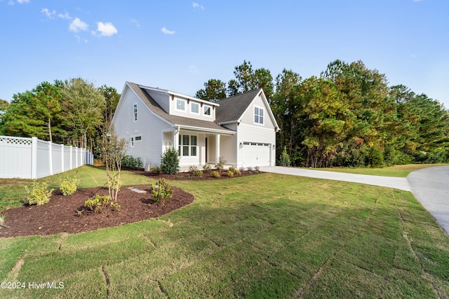 traditional-style house with a front yard, an attached garage, fence, and driveway