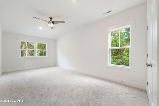 spare room with plenty of natural light, a ceiling fan, visible vents, and carpet floors