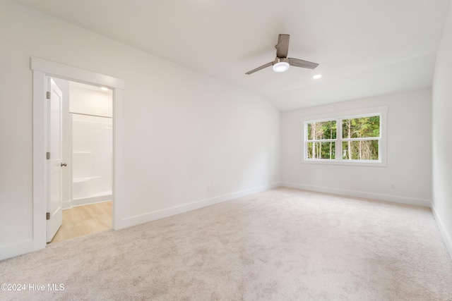 carpeted spare room featuring baseboards and a ceiling fan