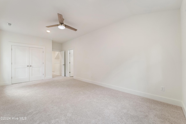 unfurnished bedroom with lofted ceiling, a ceiling fan, a closet, carpet floors, and baseboards