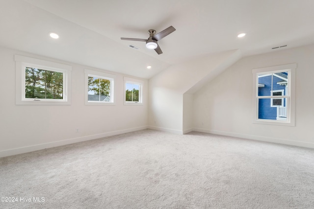 additional living space with visible vents, ceiling fan, lofted ceiling, and carpet