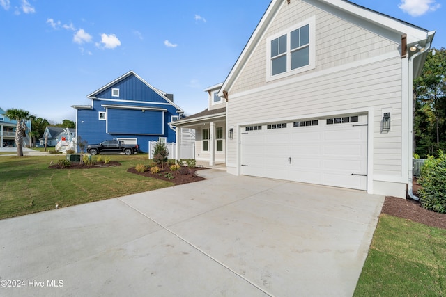 view of front of house with a garage, a front lawn, and a porch