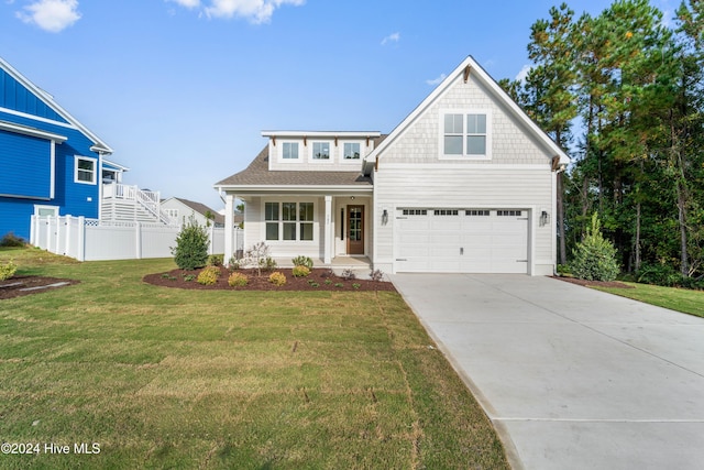 view of front facade featuring a shingled roof, fence, a porch, concrete driveway, and a front yard