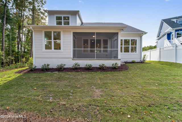 rear view of property with a yard and a sunroom