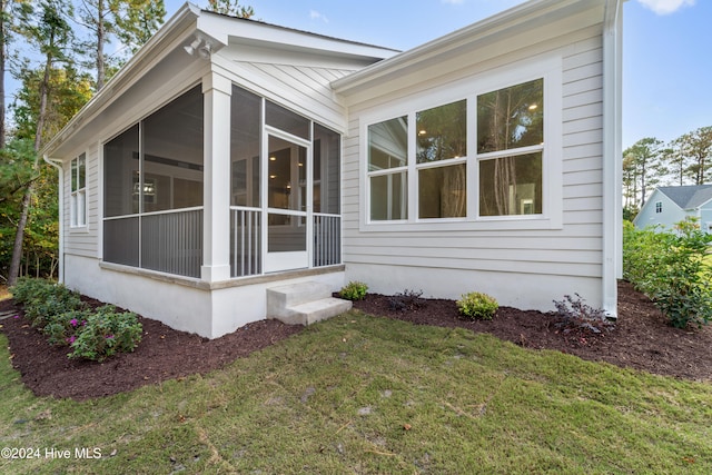 exterior space with a front lawn and a sunroom