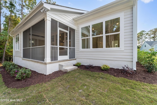 view of side of property with a lawn and a sunroom