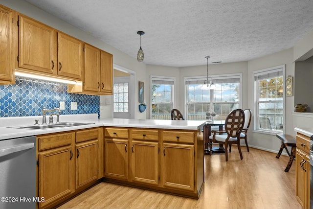 kitchen with dishwasher, sink, plenty of natural light, and hanging light fixtures