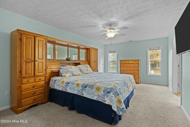 carpeted bedroom featuring a textured ceiling and ceiling fan