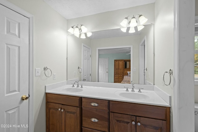 bathroom featuring vanity, a textured ceiling, and toilet