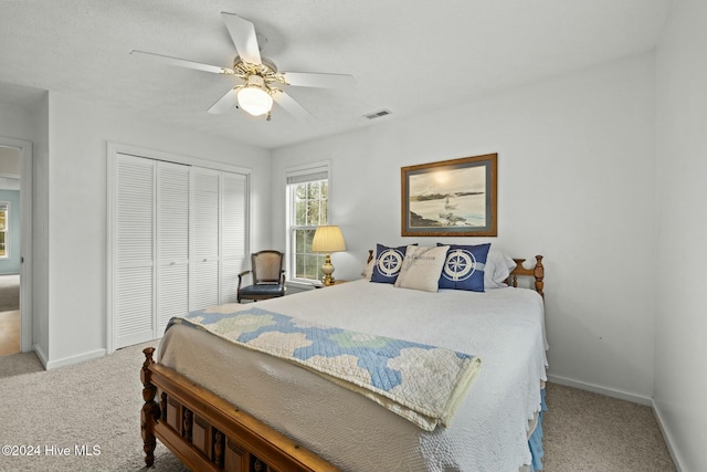 bedroom with a closet, ceiling fan, and light colored carpet