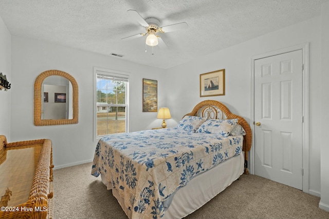 carpeted bedroom with ceiling fan and a textured ceiling