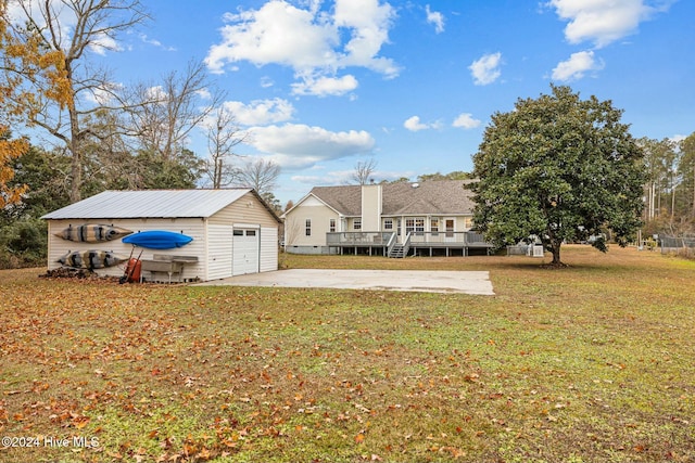 view of yard featuring an outbuilding, a garage, and a deck