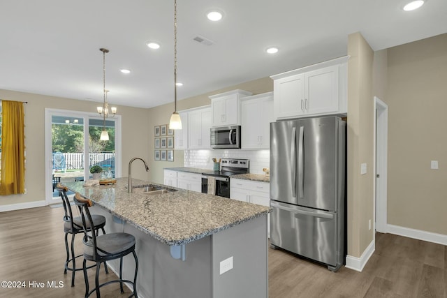 kitchen featuring a kitchen island with sink, sink, white cabinets, and appliances with stainless steel finishes