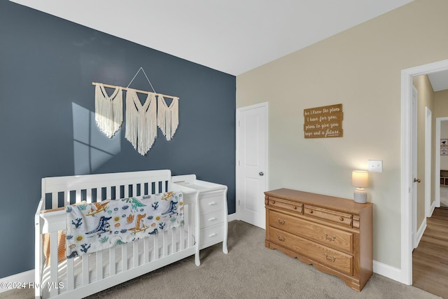 bedroom with light carpet and a crib