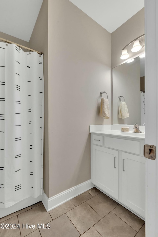 bathroom with tile patterned flooring, vanity, and curtained shower