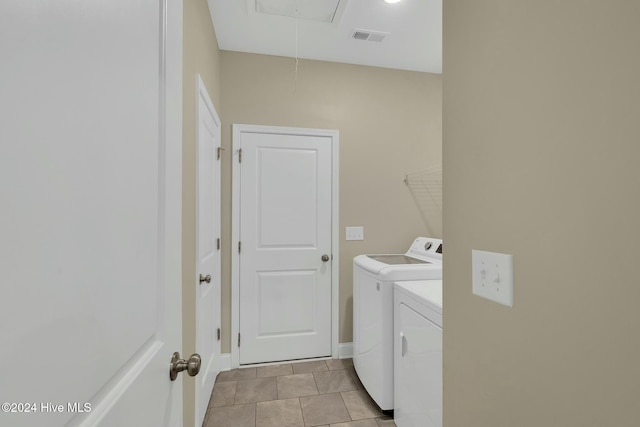 laundry area with washer and dryer and light tile patterned flooring