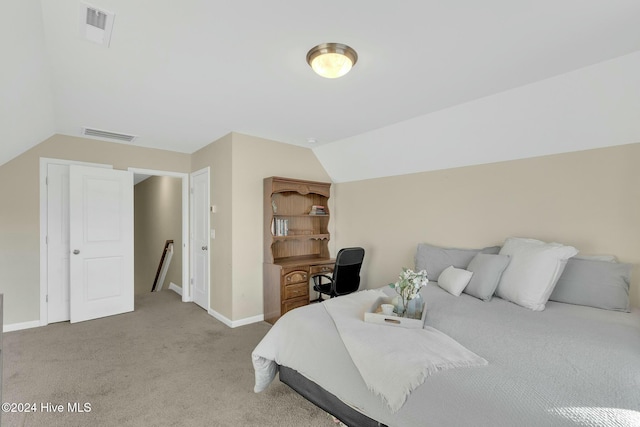 carpeted bedroom with lofted ceiling