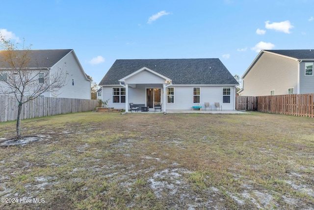 rear view of house with a lawn and a patio