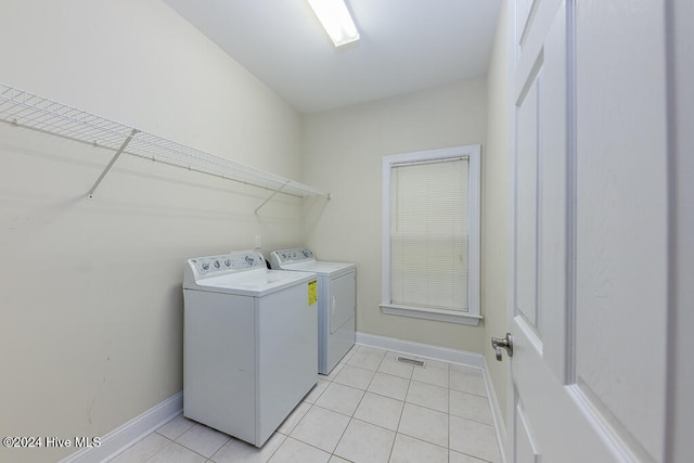 washroom with washing machine and clothes dryer and light tile patterned floors