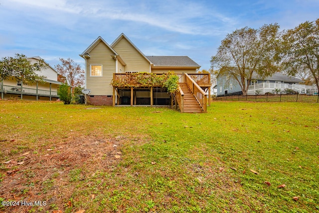 back of property with a lawn and a deck