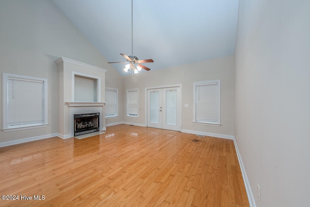 unfurnished living room with light wood-type flooring, high vaulted ceiling, and ceiling fan