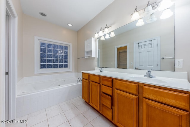 bathroom with tile patterned floors, vanity, and tiled bath