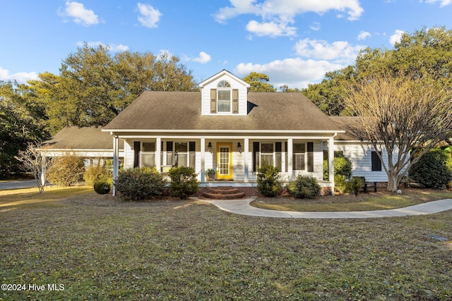 cape cod-style house featuring covered porch and a front yard