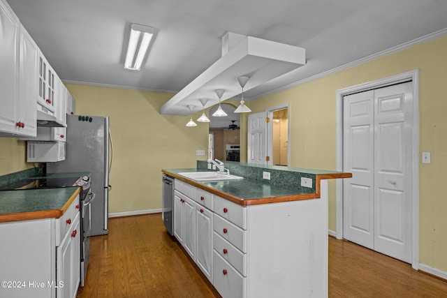 kitchen featuring hardwood / wood-style floors, stainless steel appliances, white cabinetry, and sink