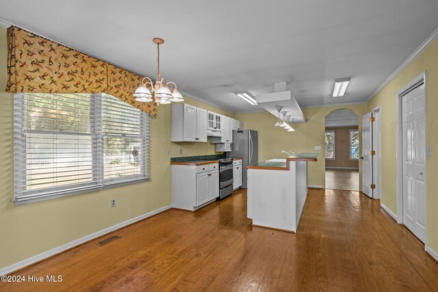 kitchen with dark hardwood / wood-style floors, white cabinetry, stainless steel appliances, and ornamental molding