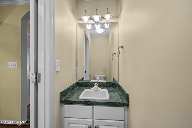 bathroom with vanity, toilet, and ornamental molding