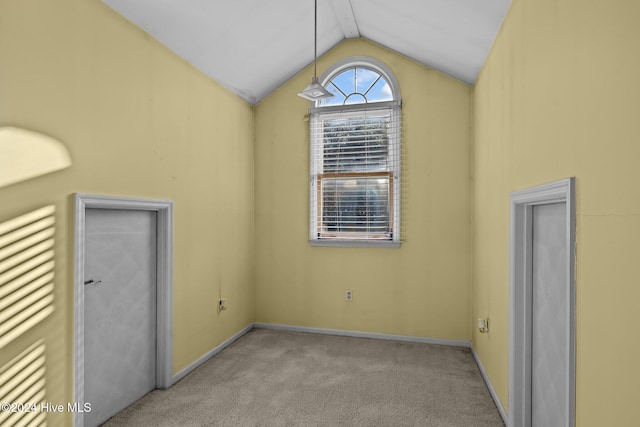 carpeted spare room with lofted ceiling