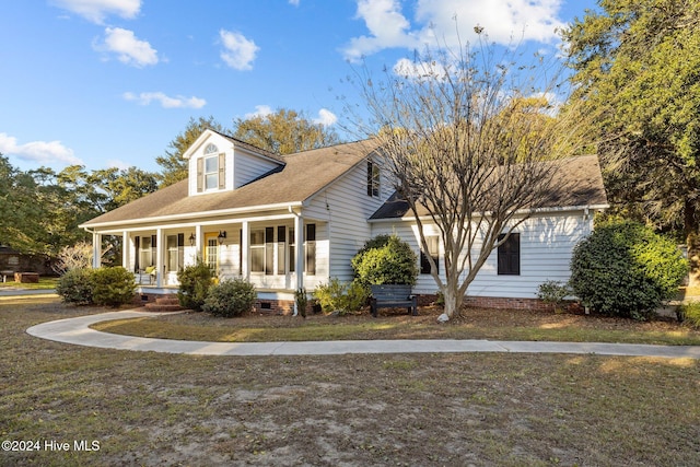 cape cod house with a front lawn and covered porch