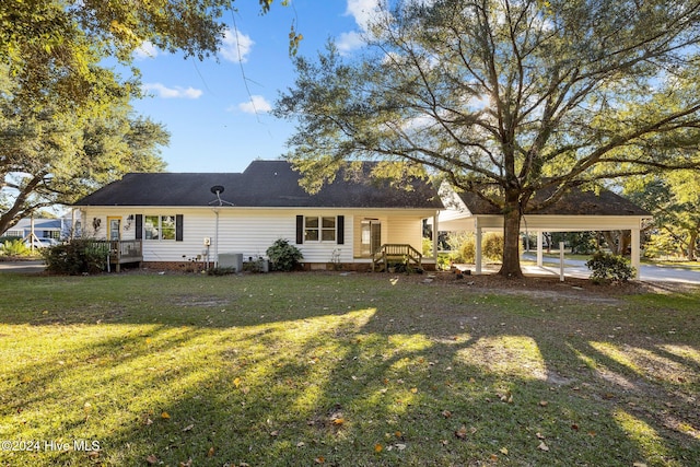 back of house with central AC, a carport, and a lawn