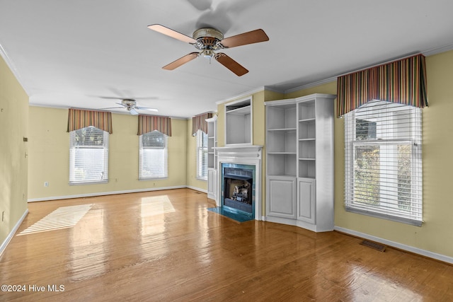 unfurnished living room with crown molding, hardwood / wood-style floors, and ceiling fan