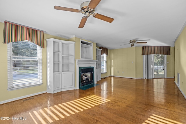 unfurnished living room featuring hardwood / wood-style floors, plenty of natural light, and ceiling fan