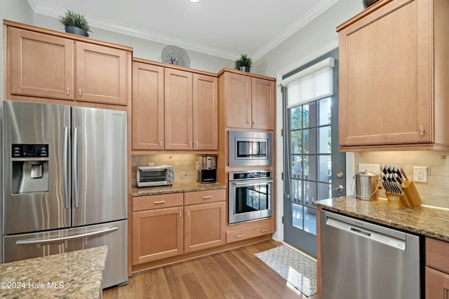 kitchen featuring crown molding, light wood-type flooring, tasteful backsplash, light stone counters, and stainless steel appliances