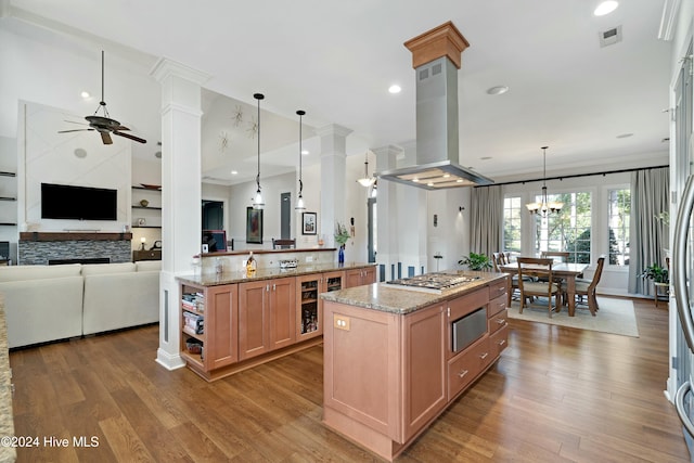 kitchen featuring kitchen peninsula, island range hood, light hardwood / wood-style flooring, a center island, and hanging light fixtures