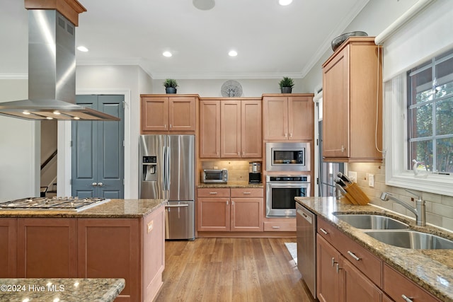 kitchen featuring light stone countertops, island range hood, sink, and stainless steel appliances